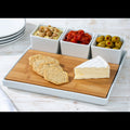 A cheese platter set consisting of a tray and three mini bowls with various cheeses and accompaniments, presented on a bamboo wood board.